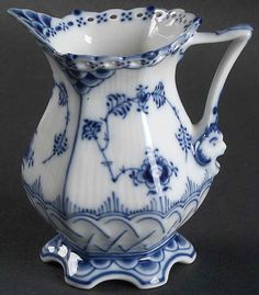 a blue and white porcelain pitcher sitting on a table