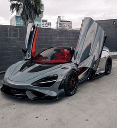 a grey sports car with its doors open