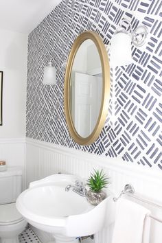 a white sink sitting under a mirror in a bathroom