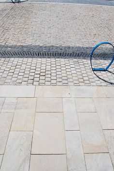 a blue bench sitting on the side of a road next to a bike rack and street