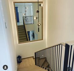 a mirror is hanging on the wall next to a stair case with railings and handrails