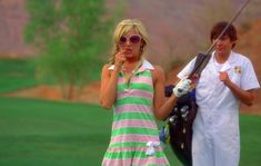 a man and woman standing next to each other holding golf clubs