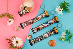 three personalized photo keychains with flowers and seashells next to them