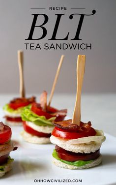 mini sandwiches with bacon, lettuce and tomato on them sitting on a white plate