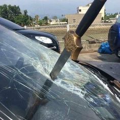 a knife stuck in the windshield of a car that has been hit by another car