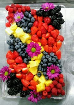 a plastic container filled with fruit and flowers