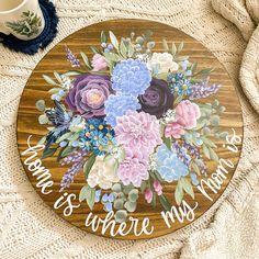 a wooden sign with flowers on it that says, mom is where my heart is