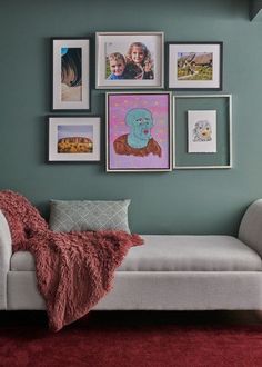 a living room with pictures on the wall and a futon couch in front of it