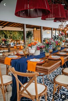 a long table with place settings and flowers on it