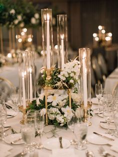 a table topped with lots of white flowers and candles