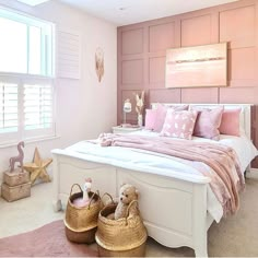 a bedroom with pink walls, white bedding and two teddy bears on the floor