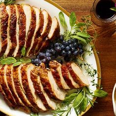 slices of sliced chicken on a plate with blueberries and grapes