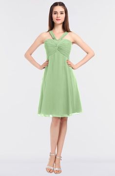 a woman in a green dress posing for the camera with her hands on her hips