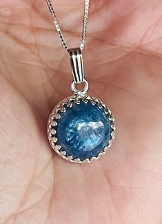 "6-Carats, natural round, 12mm, cabochon, blue (blue--silvery) Kyanite gemstone pendant necklace set in 925 sterling silver crown bezel setting, with 18\" inches long chain. Blue kyanite is a good luck stone, especially when it comes to wealth and career. Owning a blue kyanite and wearing it close to your body will fill you with the energies that will attract good luck to you!" Gemstone Pendant Necklace, Silver Crown, Good Luck To You, Blue Kyanite, Gemstone Necklace Pendant, Long Chain, Bezel Setting, Sterling Silber, Gemstone Pendant