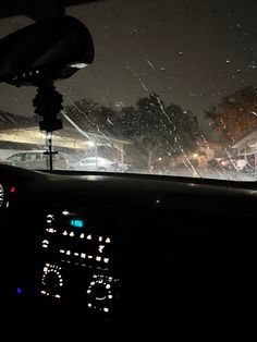 the dashboard of a car with rain falling on it