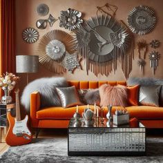 a living room with an orange couch and lots of mirrors on the wall above it