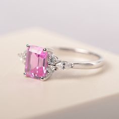 All HANDMADE ITEMS SHIP IN APPROX 8 DAYS Main Stone: Lab created pink sapphire Main Stone Size: Emerald cut 6 mm x 8 mm Main Stone Weight: 1.75 carat Side Stone: CZs Height From The Ring Setting Bottom(to gemstone top): about 5.13 mm Width of Ring band Measure: gradually varied,about 1.67 to 1.91 mm Material: .925 Sterling Silver/14K White Gold/14K Yellow Gold/14k Rose Gold Engraved: Available For FreeNo more than 13 letters) Customized:Of course! Tell me what you want Includes With Order: All o Fine Jewelry Pink Sapphire Ring With Emerald Cut, Pink Emerald Cut Sapphire Ring In Fine Jewelry Style, Pink Sapphire Emerald Cut Ring For Anniversary, Rectangular Silver Sapphire Ring, Fine Jewelry Pink Emerald-cut Sapphire Ring, Rectangular White Gold Sapphire Ring For Anniversary, Pink Emerald Cut Sapphire Ring Fine Jewelry, Emerald Cut Pink Sapphire Ring For Anniversary, Rectangular Sapphire Promise Ring