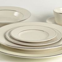 a set of white dinner plates with silver rims