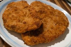 two fried meat patties on a white and blue plate