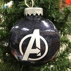 an avengers ornament hanging from a christmas tree with the letter a on it