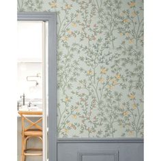 an open door leading to a kitchen with wallpaper