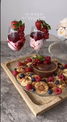 two desserts are on a tray with fruit