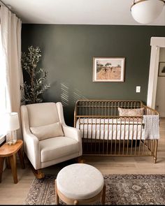 a baby's room with a crib, rocking chair and footstool