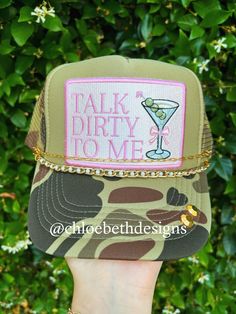 a hand holding up a green hat with a drink on it and the words talk dirty to me