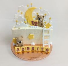 a birthday cake with teddy bears and stars on the top, sitting on a table