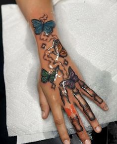 a woman's hand with butterflies painted on it