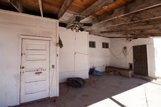 an empty room with two doors and a ceiling fan