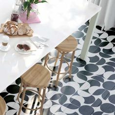 a white counter top sitting next to two wooden stools