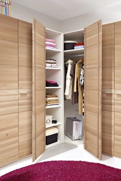 an open closet with wooden doors and drawers