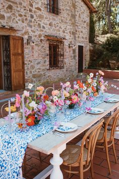 a long table with flowers and plates on it