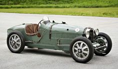 an old green car is parked on the pavement