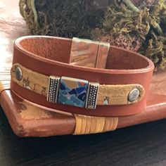 a brown leather bracelet with mountains on it