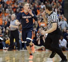 an image of a man that is running on the court with his mouth open and referee in the background