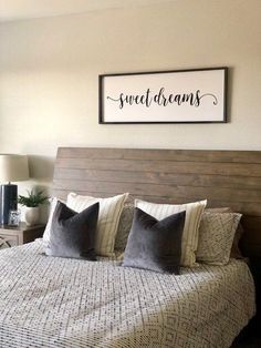 a bedroom with a bed, nightstand and framed sign on the wall above it that says sweet dreams