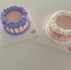 two cakes sitting on top of each other with frosting and icing designs in them