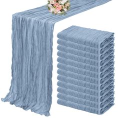 a stack of blue cloths with flowers on top and one folded in the middle