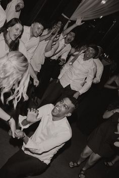 a group of people standing around each other on a dance floor