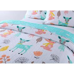 a bed with colorful deers and trees on it