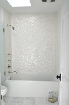 a bathroom with a white bath tub sitting under a skylight