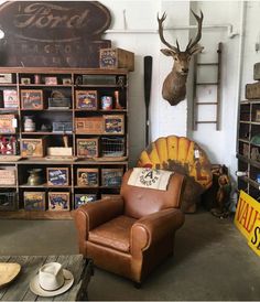 a room filled with lots of wooden crates and shelves next to a wall mounted deer head