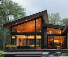 a modern house in the woods with lots of windows and lights on it's roof