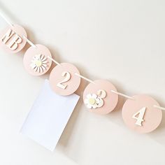 a pink and white birthday banner with flowers on it