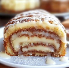 a piece of cake sitting on top of a plate covered in icing and powdered sugar