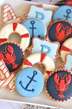 decorated cookies in the shape of boats, anchors and life preservers on a plate