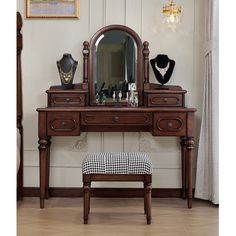 an antique dressing table with mirror and stool