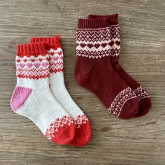 two pairs of socks sitting on top of a wooden floor next to each other,